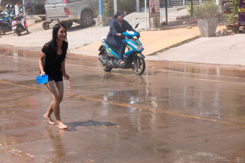 Tropfnasse Frau auf der Straße während Songkran auf Koh Lanta