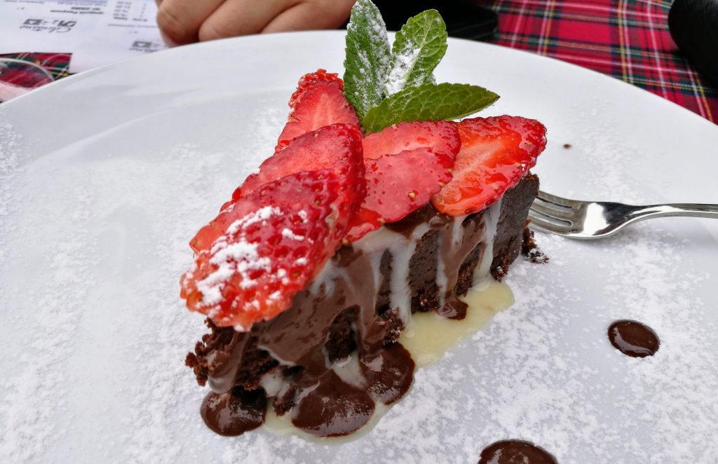 Brownie-Kuchen mit frischen Erdbeeren und Schokosoße im Celentano Ristorante